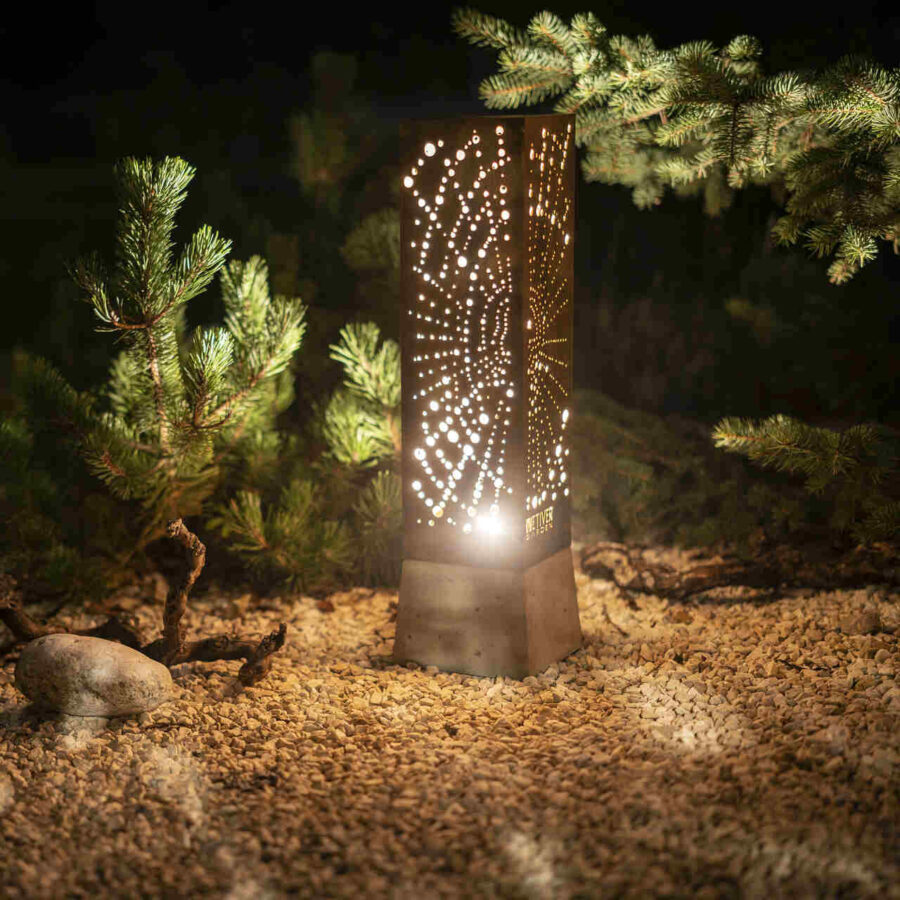 Wyjątkowa lampa ogrodowa z cortenu z wypalonym wzorem pajęczyny rozświetlająca nocą zakątek ogrodu.