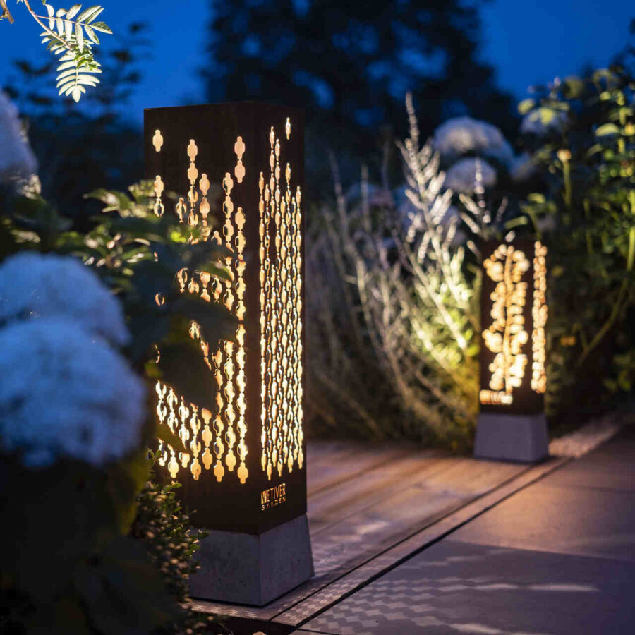 Wieczorna aranżacja lamp ogrodowych na tarasie.