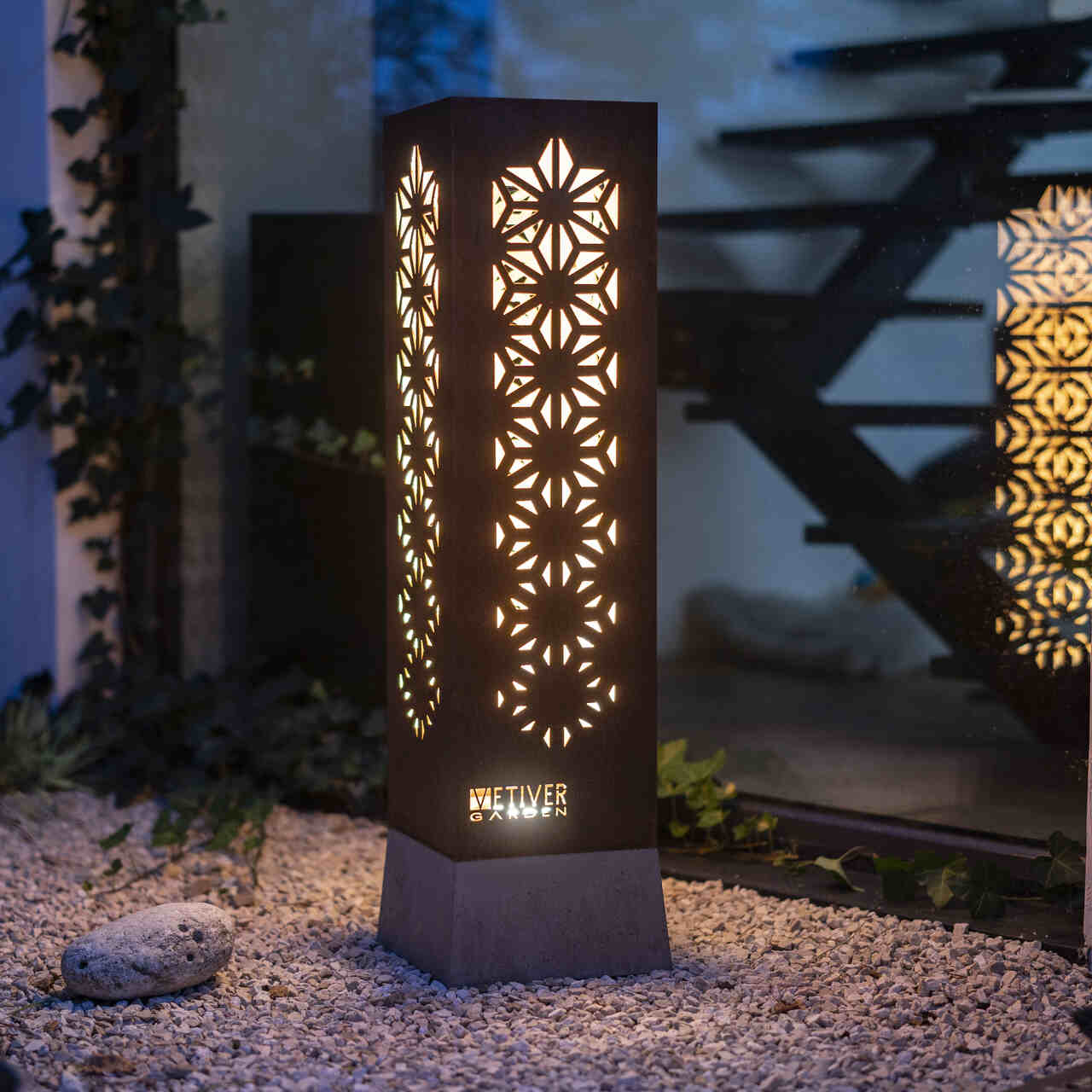 Lampion zewnętrzny ze świecącym wzorem geometrycznym.